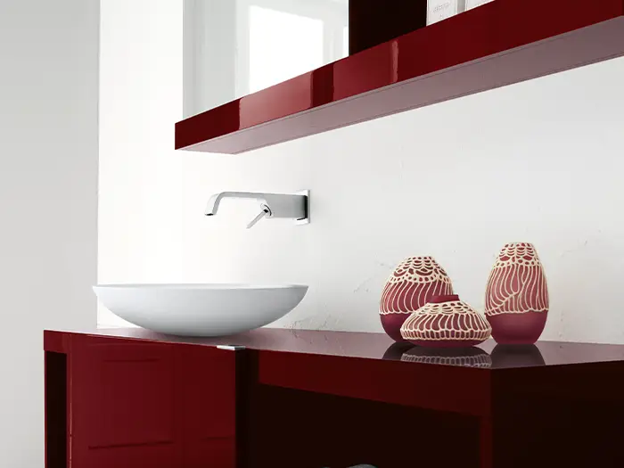 modernes, schlichtes Waschbecken mit dunkelrotem Hochglanz-Unterschrank