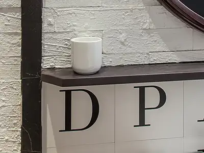 dunkle Stein-Ablage mit Buchstaben-Motivfliesen von der Rieger – Ihre Bäderschmiede