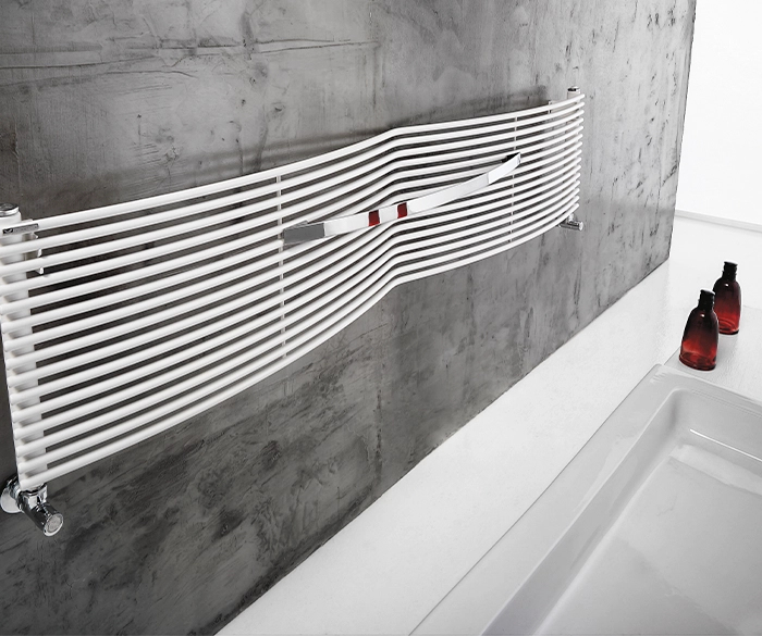 moderner, länglicher Wandheizkörper mit Handtuchhalter über Badewanne
