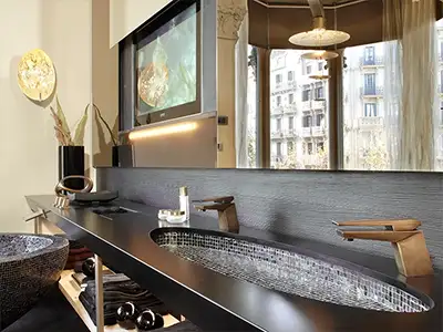 modernes Luxus-Bad mit schwarz-goldenem Waschbecken mit Mosaikakzenten