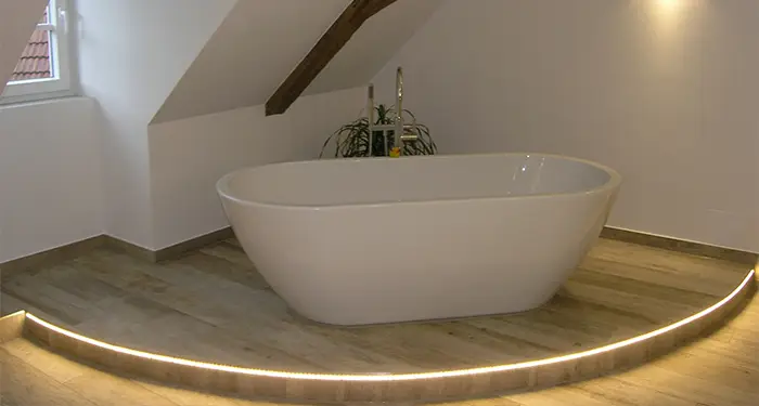 freistehende Badewanne auf einer beleuchteten Plattform