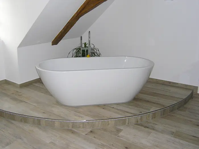freistehende Badewanne auf LED-besetzter Stufe von der Rieger – Ihre Bäderschmiede