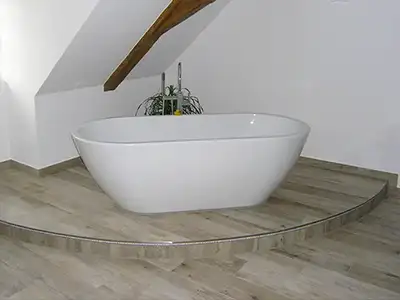 freistehende Badewanne auf LED-besetzter Stufe von der Rieger – Ihre Bäderschmiede