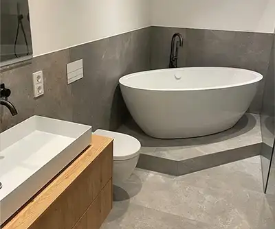 modernes, edles Badezimmer mit erhöhter, freistehender Badewanne von der Rieger – Ihre Bäderschmiede