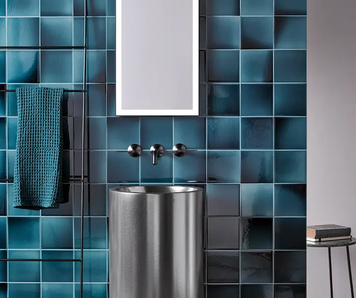 modernes, freistehendes Waschbecken aus Metall mit blauen Hochglanz-Wandfliesen